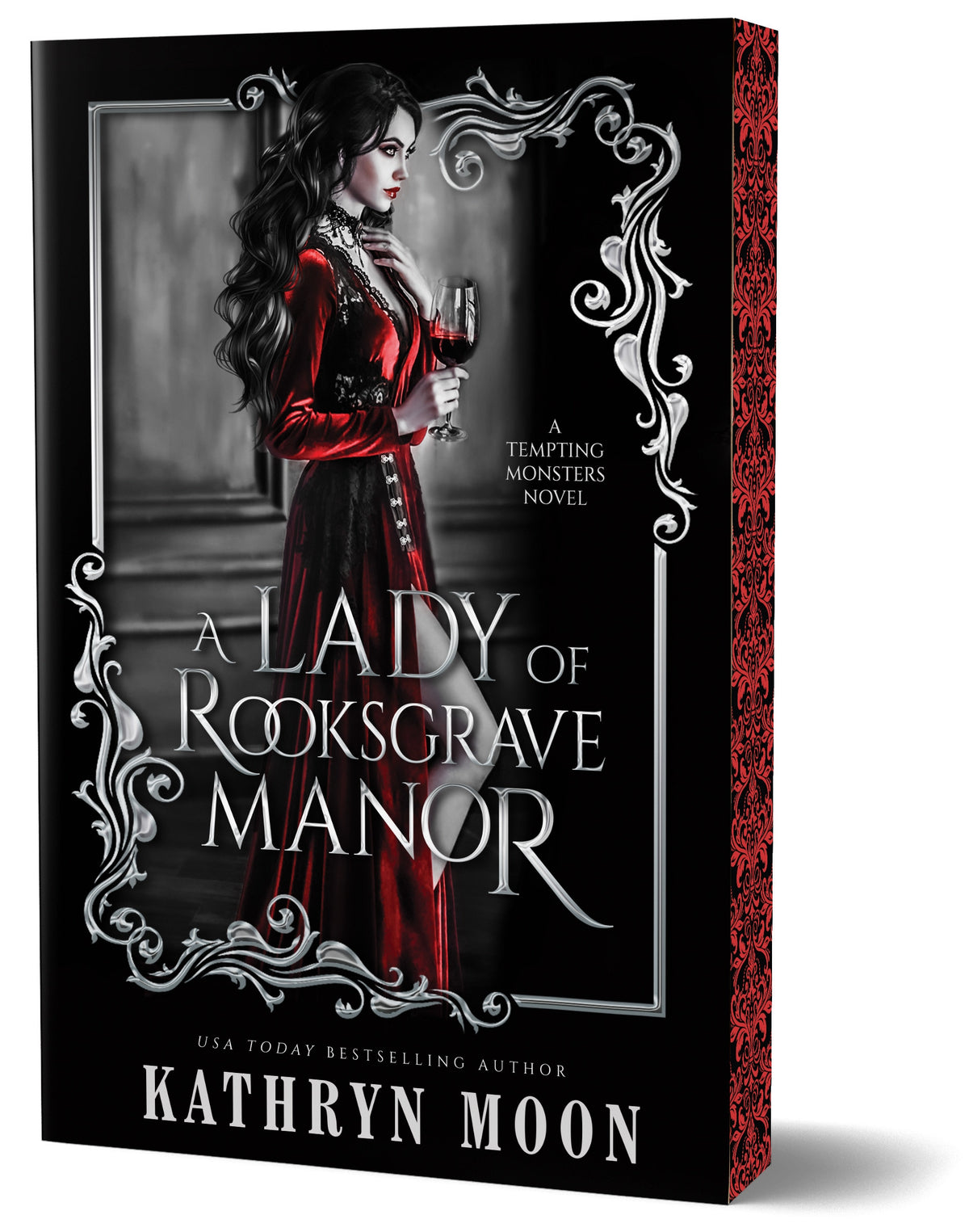 Book cover for 'A Lady of Rooksgrave Manor' by Kathryn Moon, featuring a woman in a long red dress holding a wine glass against a dark gothic interior, framed by ornate silver scrollwork on a black background with matching red and black sprayed ornate edges.