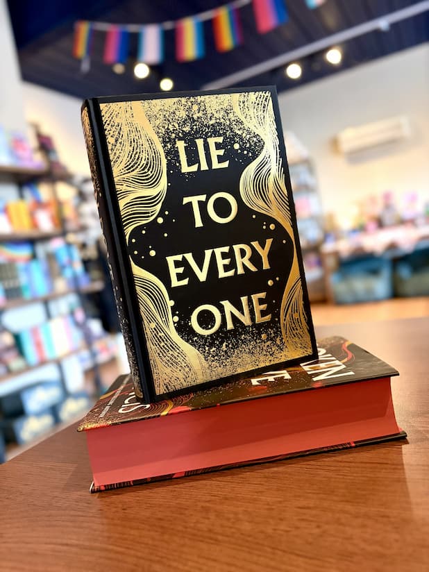 A small stack of the hardcover edition of 'Broken Dove' by Dani Francis without its dust jacket, featuring a black and gold cover with a large gold title.
