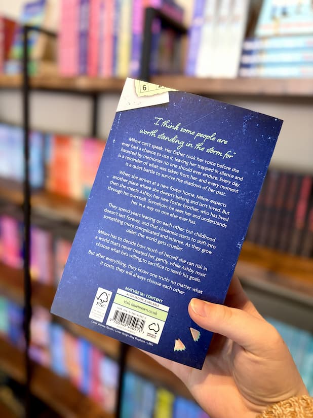 A hand holding the back cover for 'Close to You' by Nissa Renzo, featuring a textured dark blue background with white text.