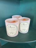 Three white wax melts in clear jars with round cream labels, stacked on a dark teal shelf. The label features the brand name 'Coastal Road Trip'.