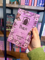 A hand holding a copy of 'Darlin' by Samantha Leigh, featuring a purple silhouette of a man and woman embracing with foreheads touching on a purple background, framed by light purple daisies, a cowboy hat and cowboy boots.