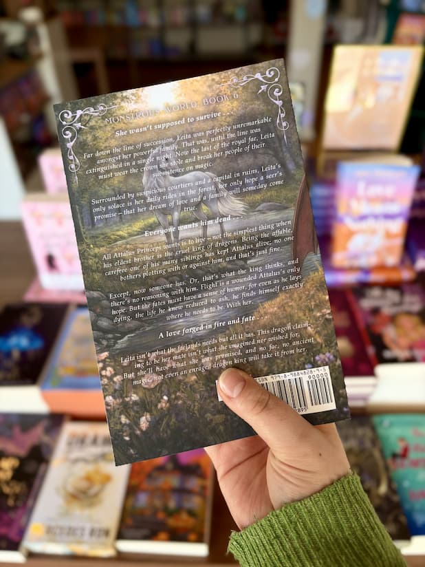A hand holding a copy of 'Foundling' by S.E. Wendel featuring a fantasy forest with a unicorn by a river and white text.
