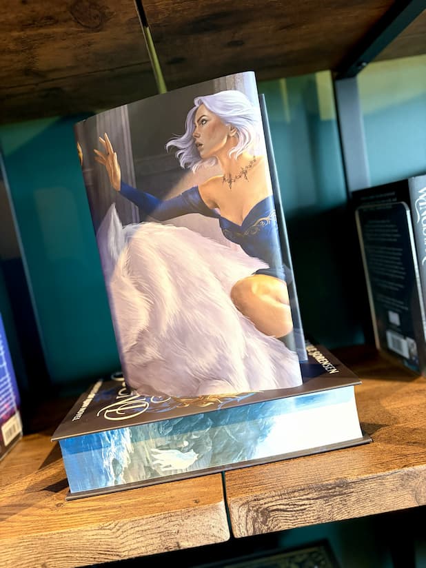 A reverse cover of 'Fury Bound' by Sable Sorensen featuring a white woman with white chin-length hair, in a blue dress, and riding a white wolf.
