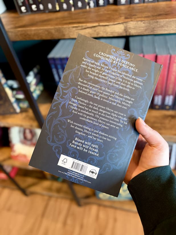 A hand holding a paperback copy of 'Fury Bound' by Sable Sorensen featuring a dark blue background with white text.