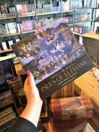 A hand with pink nail polish holds up an 1000 piece puzzle box featuring an illustration of a fantasy landscape with buildings and people, titled 'Holly Black's Isles of Elfhame'.