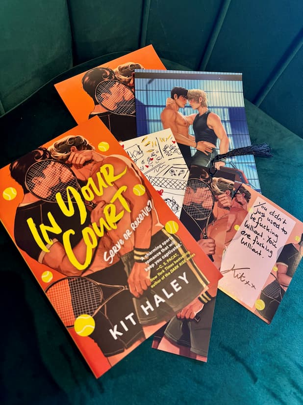 The pre-order incentive for 'In Your Court' by Kit Haley, includes 3x art prints, 1x bookmark and 1x signed bookplate. The book cover for 'In Your Court' features an illustrated tennis-themed romantic scene with two shirtless men holding tennis rackets against an orange background with yellow tennis balls.