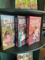 On a dark green shelf sits three Simone Soltani books in the Lights Out series: Cross the Line, Ride with Me, and Crash Into You. The spines show light blue, dark blue, and coral pink, with white titles and author names.