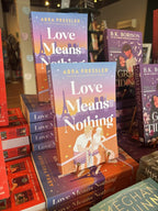 A stack of 'Love Means Nothing' by Abra Pressler, featuring a colorful illustrated tennis court scene with two players, tennis rackets, and the Eiffel Tower in the background.