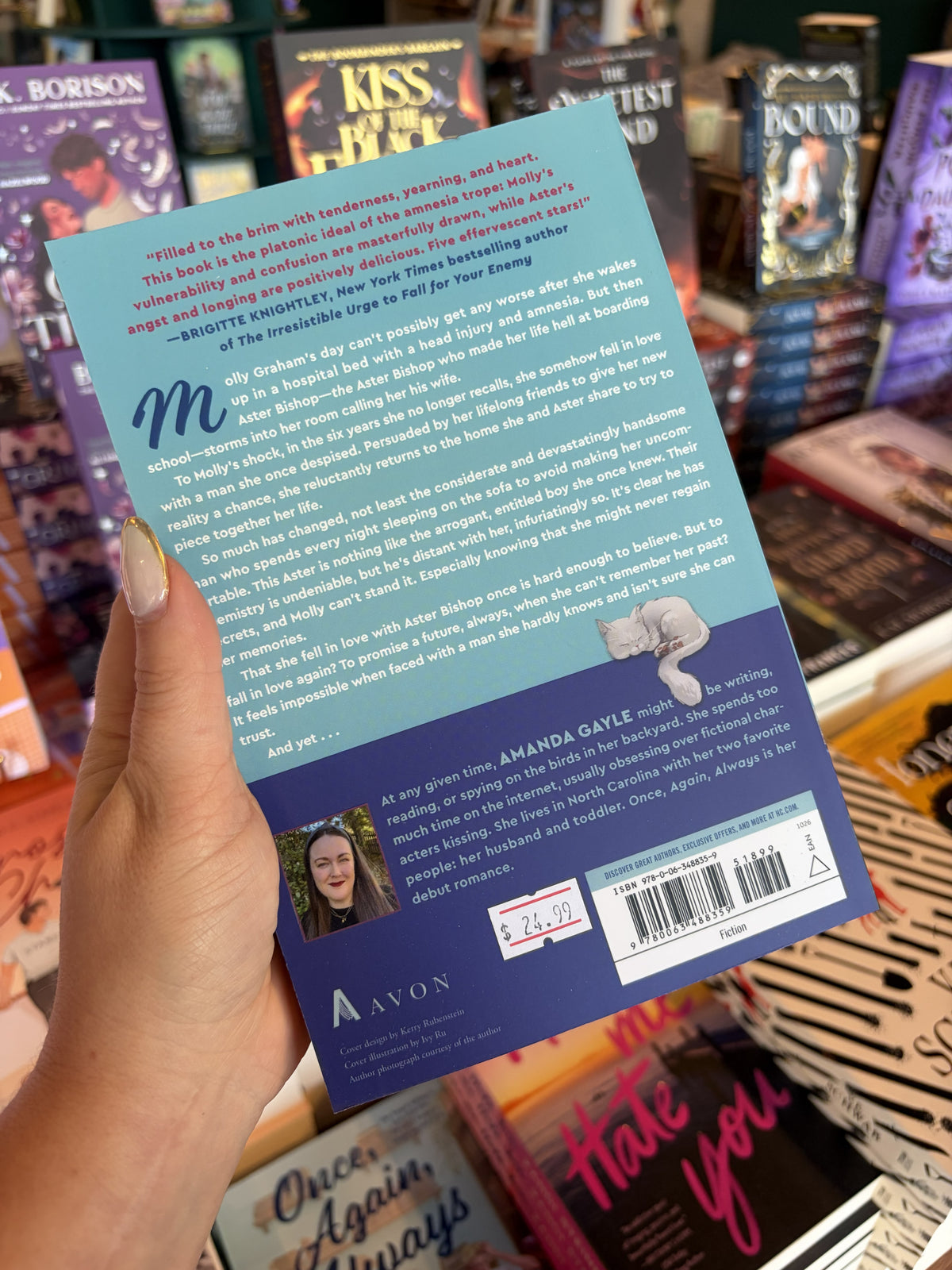 A hand with nude nail polish holding the back of a copy of 'Once, Again, Always' by Amanda Gayle, featuring a light and dark blue background with red, blue, and white text.