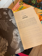 A copy of the book 'Pink Ink' by Avina St. Graves sits open to the Trigger Warning List.