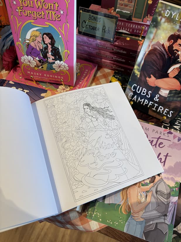 An open copy of 'Romantasy Coloring Book' with an illustration of a lady knight amongst smoke.