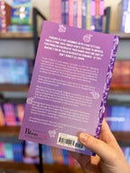 A hand holding the back of a paperback copy of 'Silver Sweet' by Krista & Becca Ritchie with a purple background and white text.