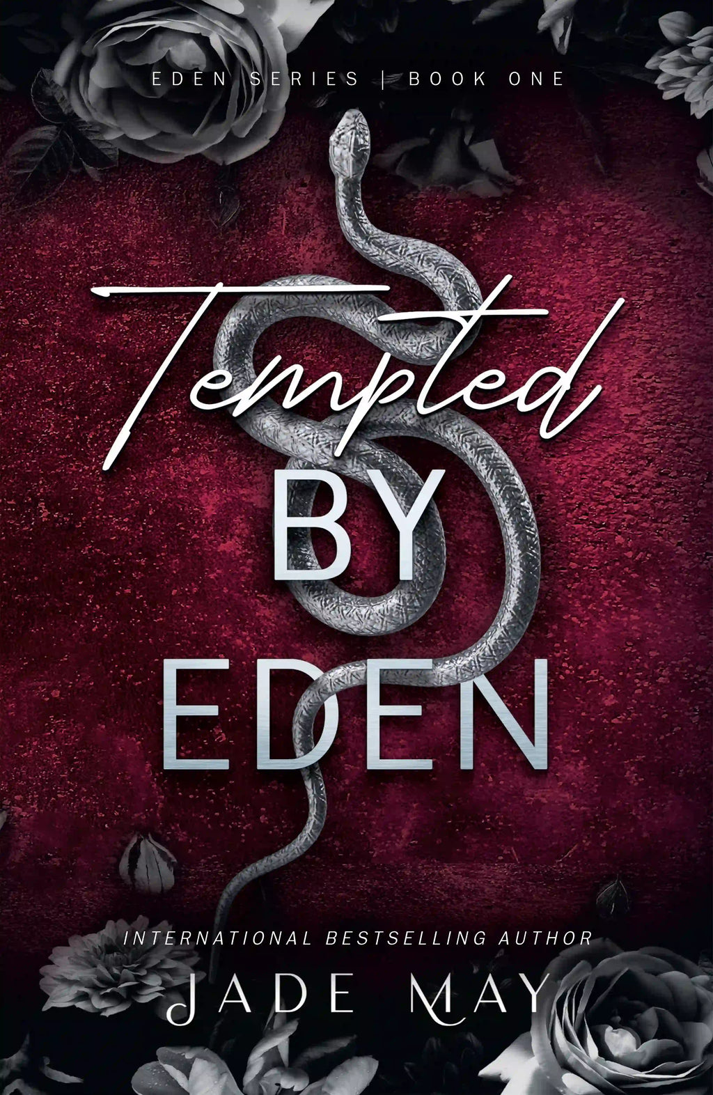 Book cover of 'Tempted by Eden' by Jae May. The cover is dark red with a grey snake in the centre and grey roses on the top and bottom of the cover.