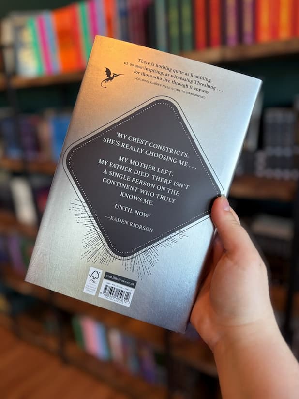 Book Cover of 'Threshing Day' by Rebecca Yarros, showing a silver cover with a black diamond in the middle with white text. 